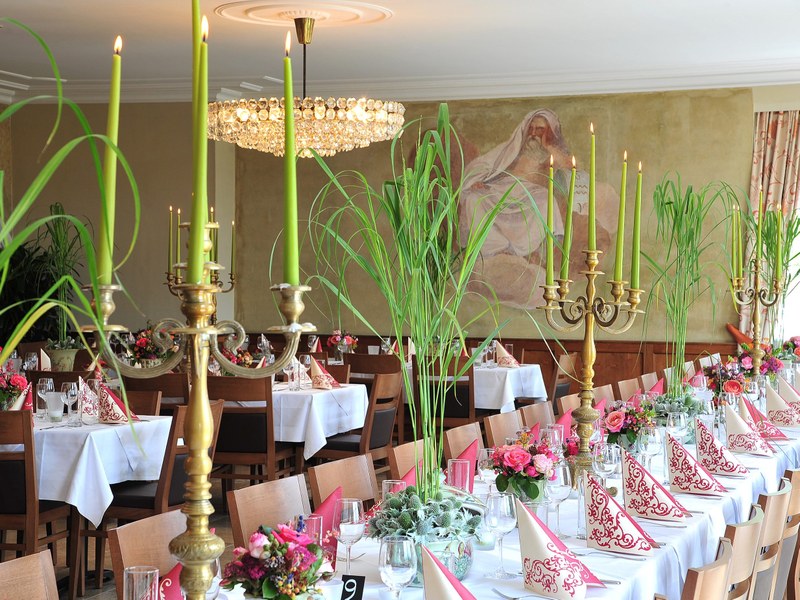 Festlich gedeckte Tafel mit Kerzenleuchtern im großen Saal