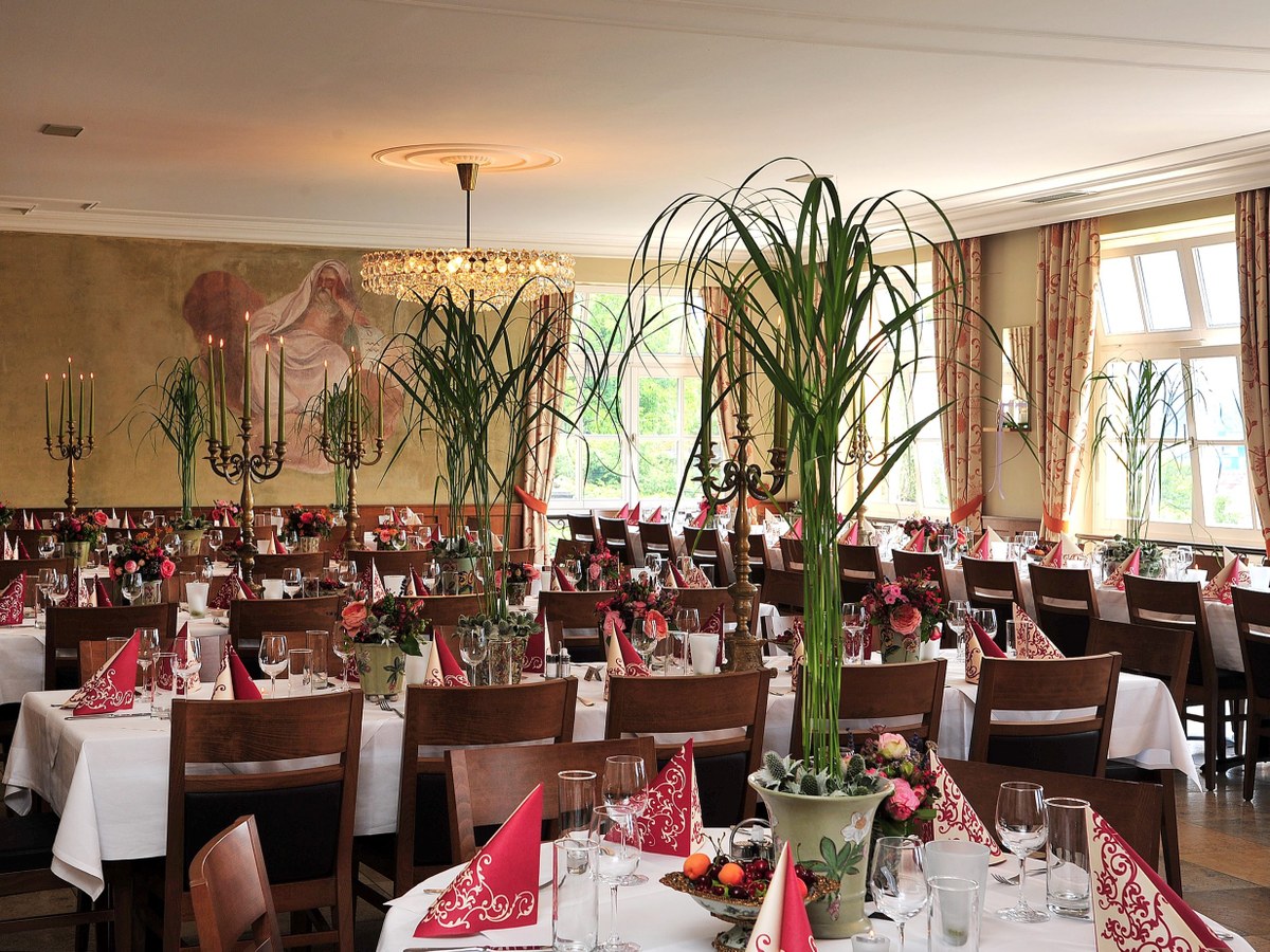 Gedeckter Saal mit Wandmalereien und Kristallluster