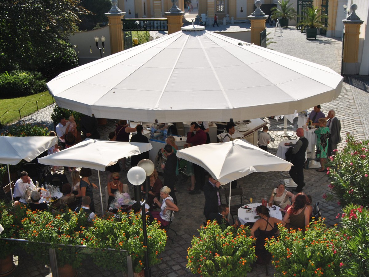 Gäste unter den großen Schirmen auf der Terrasse